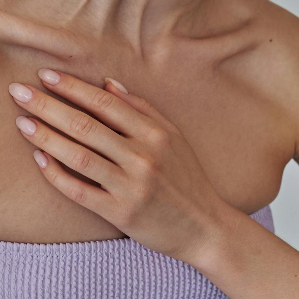 A woman with a comfortable, proportionate bust, representing the life-changing results of a breast reduction surgery at Medinova.